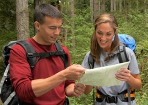 Couple-with-maps-and-compass-smiling